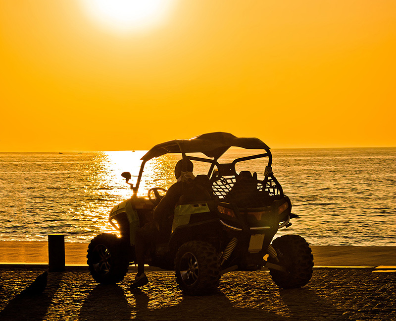 Image of dune buggy on the beach at sunset